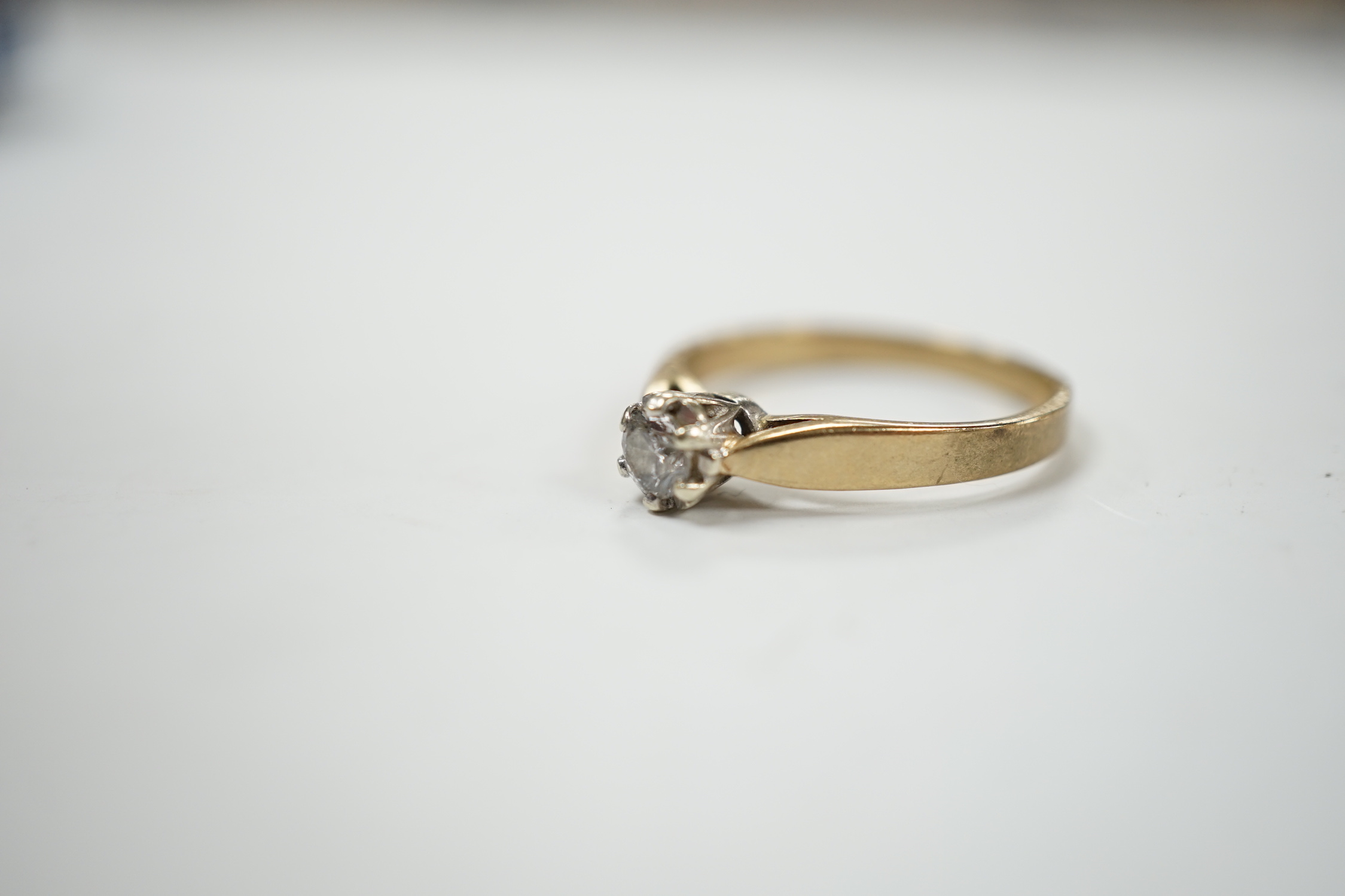 A yellow metal and solitaire diamond set ring, size N/O, gross weight 2.4 grams.